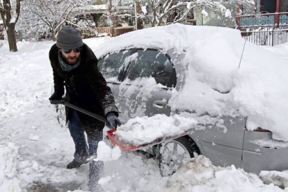 Brad Sachs saca la nieve acumulada en su coche en Indianapolis.