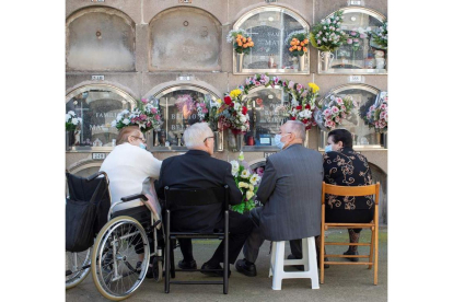 Una familia deposita flores en un cementerio de Barcelona el 1 de noviembre. MARTA PÉREZ