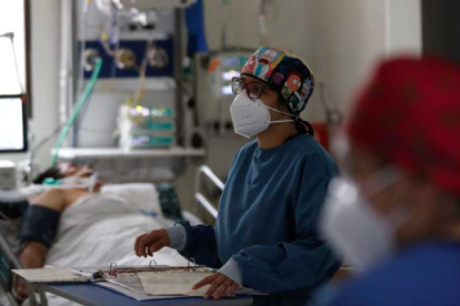 Personal métido atiende a un paciente de covid ingresado en una unidad de cuidados intensivos. EFE