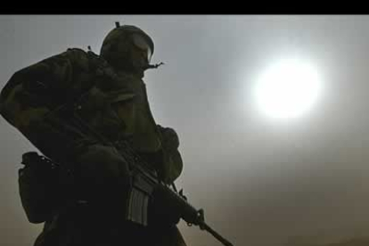 Un militar hace guardia mientras la tormenta de polvo y arena oscurece el cielo en el desierto próximo a Najaf  en el centro de Irak.