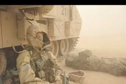 Soldados de Infantería del ejército norteamericano se refugian de la tormenta de arena tras un tanque.