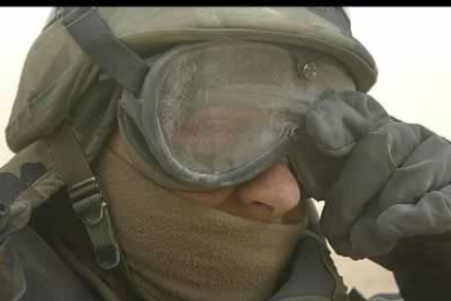Un soldado limpia la arena de sus gafas durante su turno de guardia en el desierto del sur de la ciudad de Najaf.