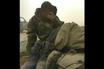 Un soldado sorprendido por la tormenta mientras dormía, despierta cubierto de arena cerca de la ciudad de Najaf.