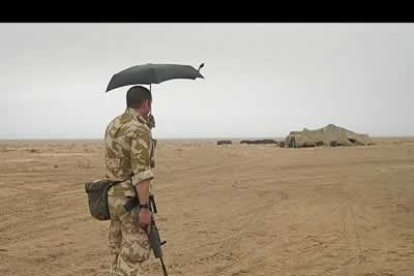 Un sargento del ejército británico usa su paraguas para protegerse de la arena en el norte del desierto de Kuwait.
