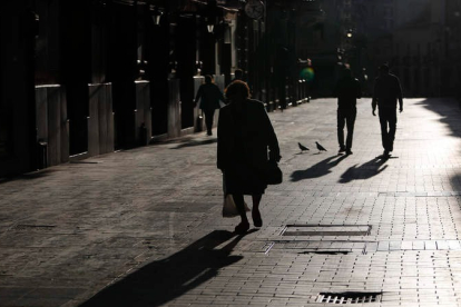 Una señora mayor camina por las calles de León cargada con las bolsas con la compra. JESÚS F. SALVADORES