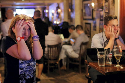 Un grupo de gente en el bar The Churchill Tavern de Manhattan (Nueva York) sigue los primeros resultados del referéndum. REUTERS / ANDREW KELLY