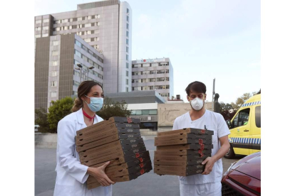 Dos sanitarios recogen pizzas en un hospital. KIKO  HUESCA