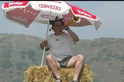 Un aficionado bajo una sombrilla para quitar el agobiante calor durante la Subida a Riego. Los aficionados que se acercaron a la zona de la prueba llegaban no sólo desde El Bierzo sino también desde Asturias y Galicia.