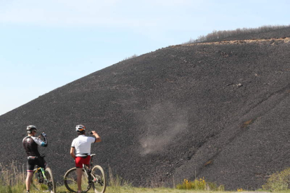 Dos ciclistas contemplaban el incendio sofocado en abril de 2017. ANA F. BARREDO