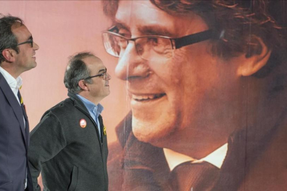 Jordi Turull y Josep Rull ante el cartel electoral de Carles Puigdemont