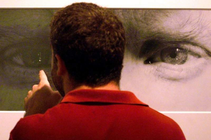 Un hombre observa un autorretrato de Mapplethorpe en una exposición