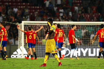 El ghanés Boubacar Haidara (c) reacciona mientras los jugadores de la selección española celebran tras vencer 3-1 a Mali en las semifinales del Mundial sub17 en el D Y Patil Stadium en Bombai, India.