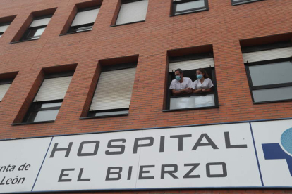 Dos profesionales sanitarios, en una de las ventanas del Hospital El Bierzo. ANA F. BARREDO