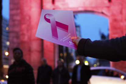 Una mujer muestra un afiche alusivo a la campaña contra el cáncer de mama. FEDERICO ANFITTI
