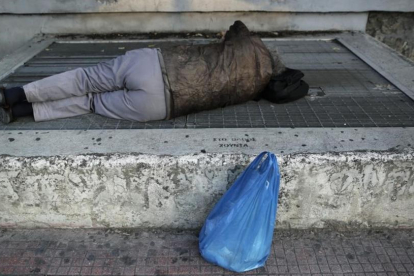 Una persona 'sintecho' duerme en la calle.