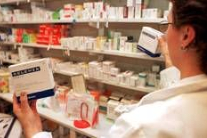 Una farmaceútica sostiene una caja de un medicamento antigripal