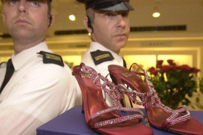 Guardias de seguridad custodian unos zapatos con rubís y platino valorados en 1,47 millones de euros, en Harrods.