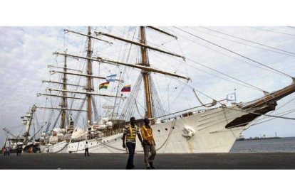 Dos trabajadores portuarios pasan ante el buque insignia de la Marina argentina, retenido en Tema, el 23 de octubre.