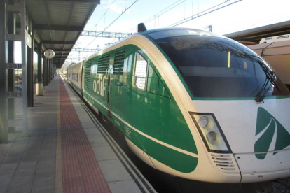 El ‘tren verde’, ayer al salir de Palencia. En pequeño, el mismo tren ya en León y trabajos de pulido del suelo de la estación ante la inminente visita de la ministra