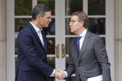 El presidente del Gobierno estrecha la mano del presidente del PP a las puertas de La Moncloa. SERGIO PÉREZ