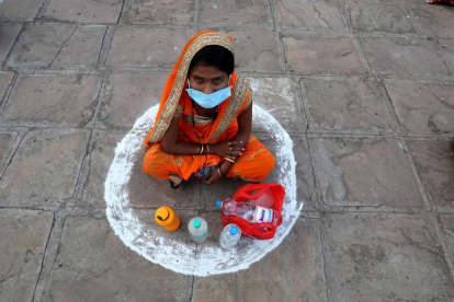 Una mujer se sienta en un área designada para mantener la distancia social en la estación de Misrod, cerca de Bhopal, India. SANJEEV GUPTA