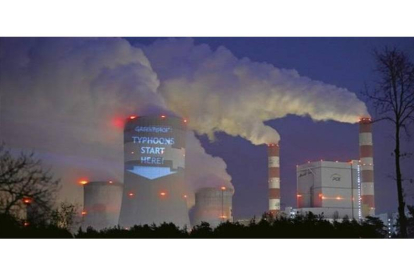 Acción de protesta de Greenpeace en una torre de refrigeración de la central térmica polaca de Belchatow, la mayor planta europea dedicada a la producción de electricidad a partir de carbón. 'Los tifones empiezan aquí', subraya el cartel.