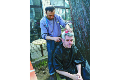Un refugiado corta el pelo al leonés Ricardo Valderrama en el asentamiento de Idomeni.