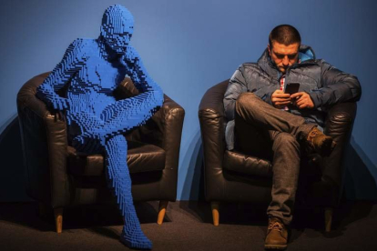 Un visitante se sienta junto a la obra ‘Blu guy seating’ realizada con 21.682 piezas de Lego en Moscú.