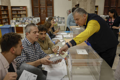 Un cartero entrega los votos emitidos por correo en una mesa electoral de Valencia. BIEL ALIÑO
