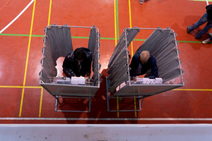 Dos votantes eligen su papeleta para participar en las elecciones de Teruel.  ANTONIO GARCÍA