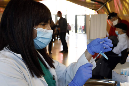 Una enfermera prepara una vacuna en el Palacio de Exposiciones de León. MARCIANO PÉREZ