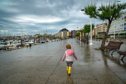 Una niña pasea por Santander este viernes, a pesar de la lluvia esta mañana. ROMÁN G. AGUILERA