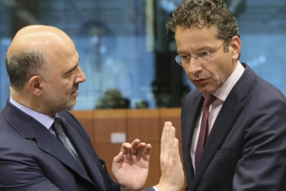 Dijsselbloem, derecha, con el comiario europeo de Asuntos Economícos, Pierre Moscovici, en este lunes en Bruselas.