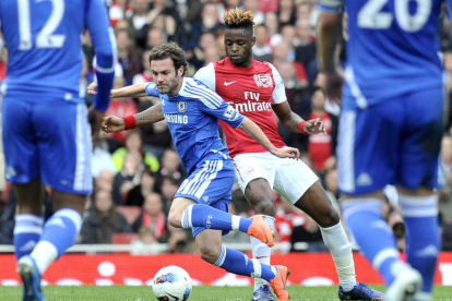 Juan Mata, a la izquierda, controla el balón bajo la presión de Alex Song del Arsenal.
