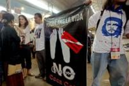 Dos jóvenes colombianos muestran una pancarta contra la Coca Cola