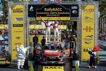 Kris Meeke (derecha) y su copiloto Paul Nagle celebran el triunfo en el Rally de Cataluña sobre el capó de su Citroën.