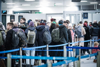 Los viajeros que llega de China hacen cola en el control del aeropuerto de Turín. TINO ROMANO