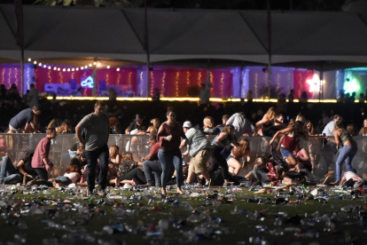 Decenas de personas corren tras el tiroteo en el festival Route 91 Harvest, este domingo en Las Vegas. /
