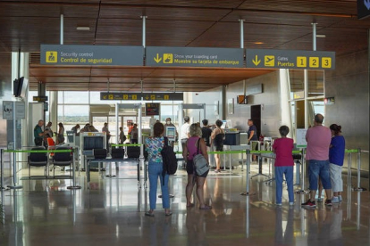 Turistas pasan el control de seguridad del Aeropuerto de La Virgen del Camino para viajar a Málaga. MIGUEL F. B.