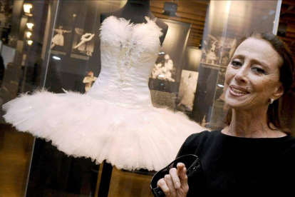 La leyenda del ballet ruso Maya Plisetskaya sonríe junto al traje que una vez usó para representar 'El lago de los cisnes'.