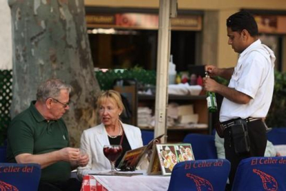 Un camarero atiende a unos clientes en establecimiento de Barcelona.