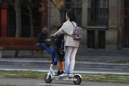Una mujer lleva a un menor en un patinete eléctrico, a mediados de noviembre, en Barcelona.