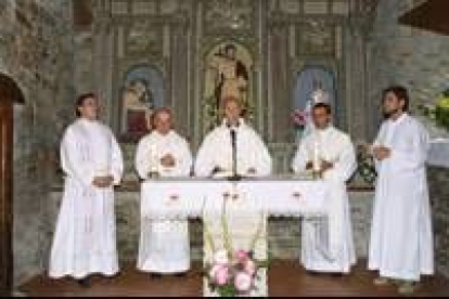 El obispo de Astorga, rodeado de sacerdotes en una imagen de archivo en la iglesia de La Portela