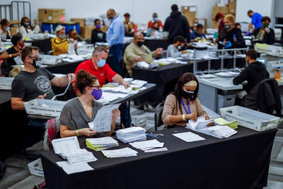 Las papeletas de voto ausente son procesadas y verificadas por el Departamento de Elecciones y Registro del Condado de Fulton en el State Farm Arena de Atlanta, Georgia. ERIK K. LESSER