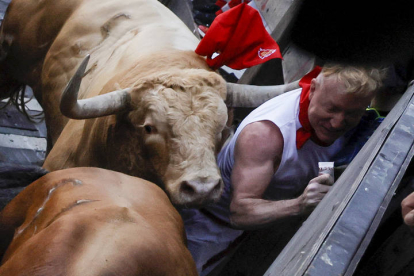 Un hombre es alcanzado por los toros en el primer encierro de los Sanfermines 2022. JESÚS DIGES