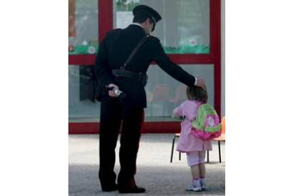 Gesto de cariño de un carabinieri con una niña a la entrada del centro