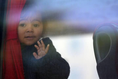 Una niña mira por la ventanilla de un autobús mientras se marcha junto a otros refugiados sirios de regreso a su país en Estambul