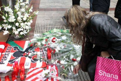 Una mujer deposita unas flores en el lugar en el que el joven Iñigo Cabacas falleció.