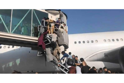 Decenas de ciudadanos afganos intentan abordar ayer un avión listo para despegar en el aeropuerto de Kabul. VÍDEO TWITTER
