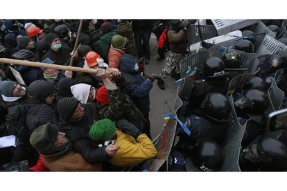 Manifestantes y policías enfrentándose junto a la sede del Gobierno ucraniano.